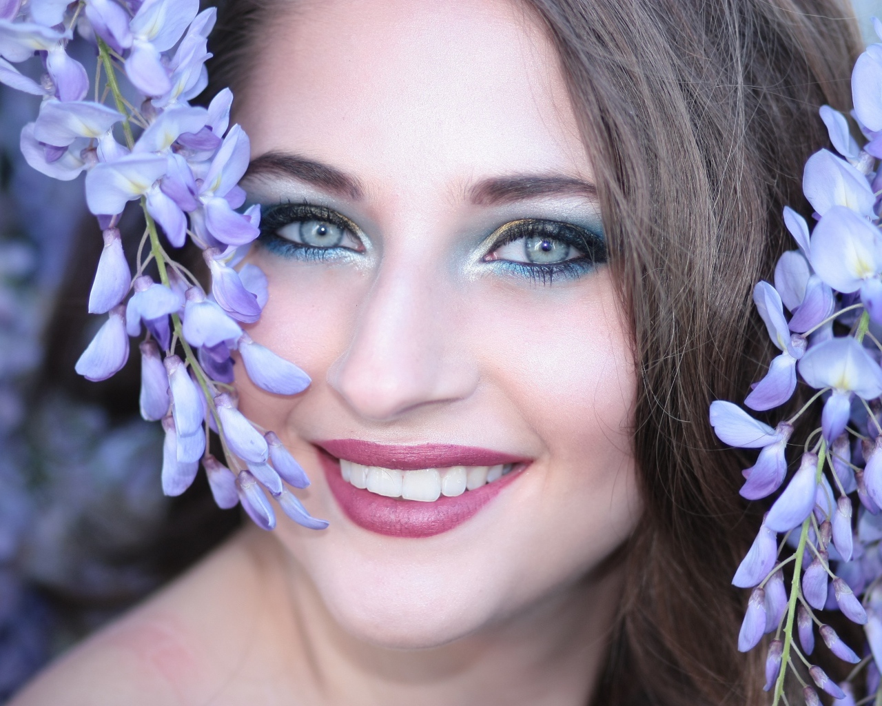 Улыбающаяся девушка с цветами глицинии