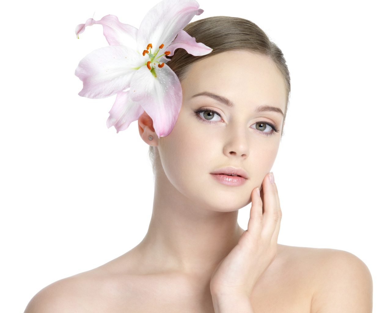 Нежная красивая девушка с лилией в волосах на белом фоне 