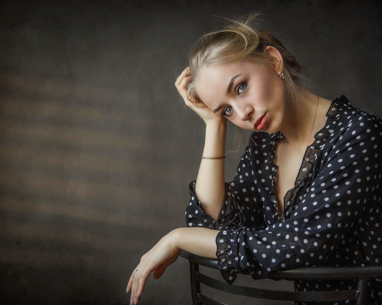 Нежная девушка блондинка сидит на стуле