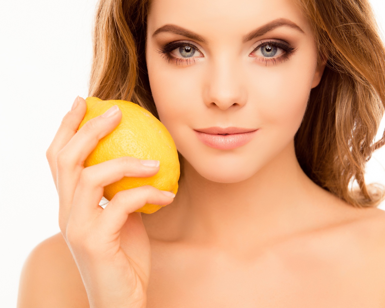 Нежная голубоглазая девушка с лимоном в руке