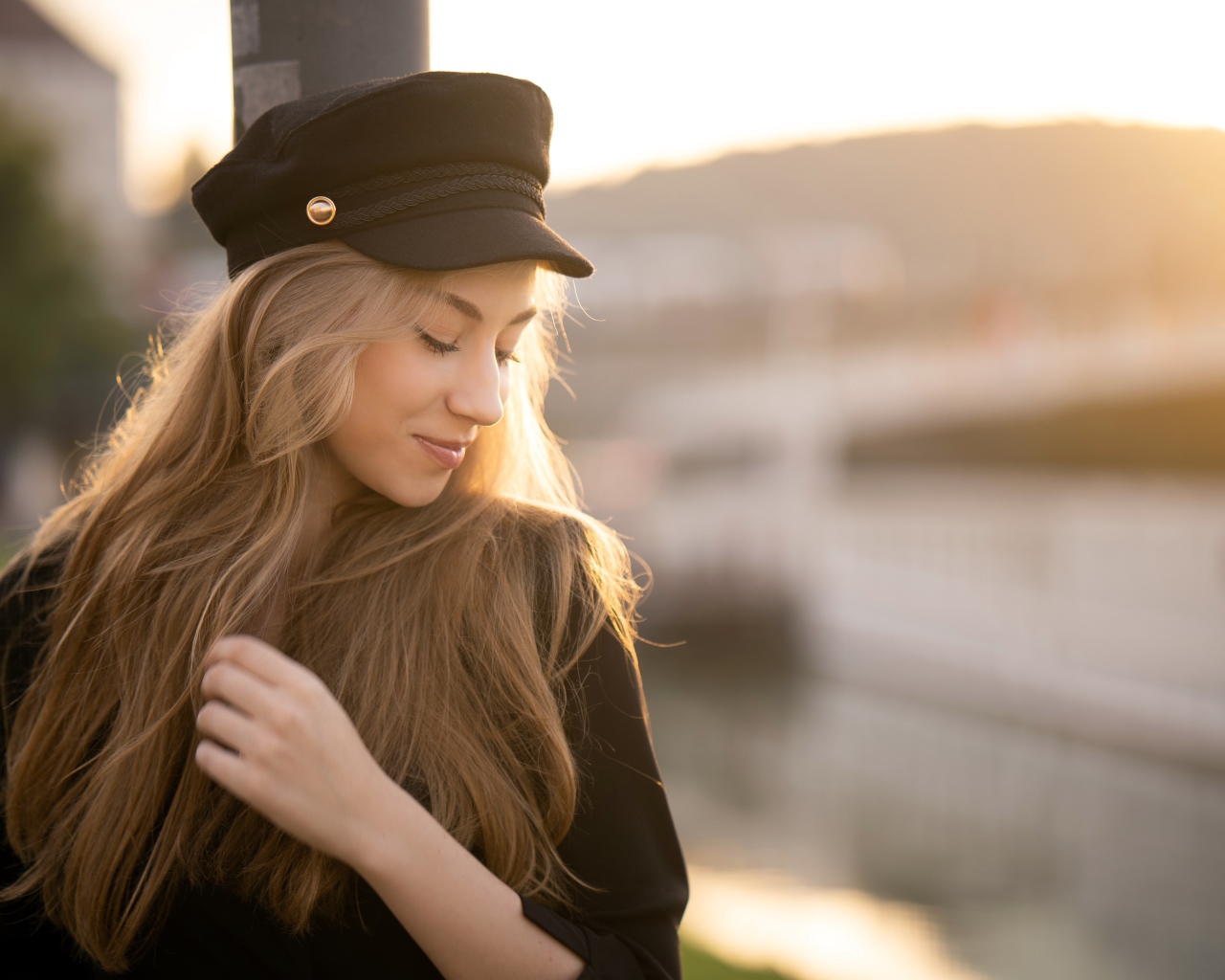 Нежная девушка в черной кепке в лучах солнца