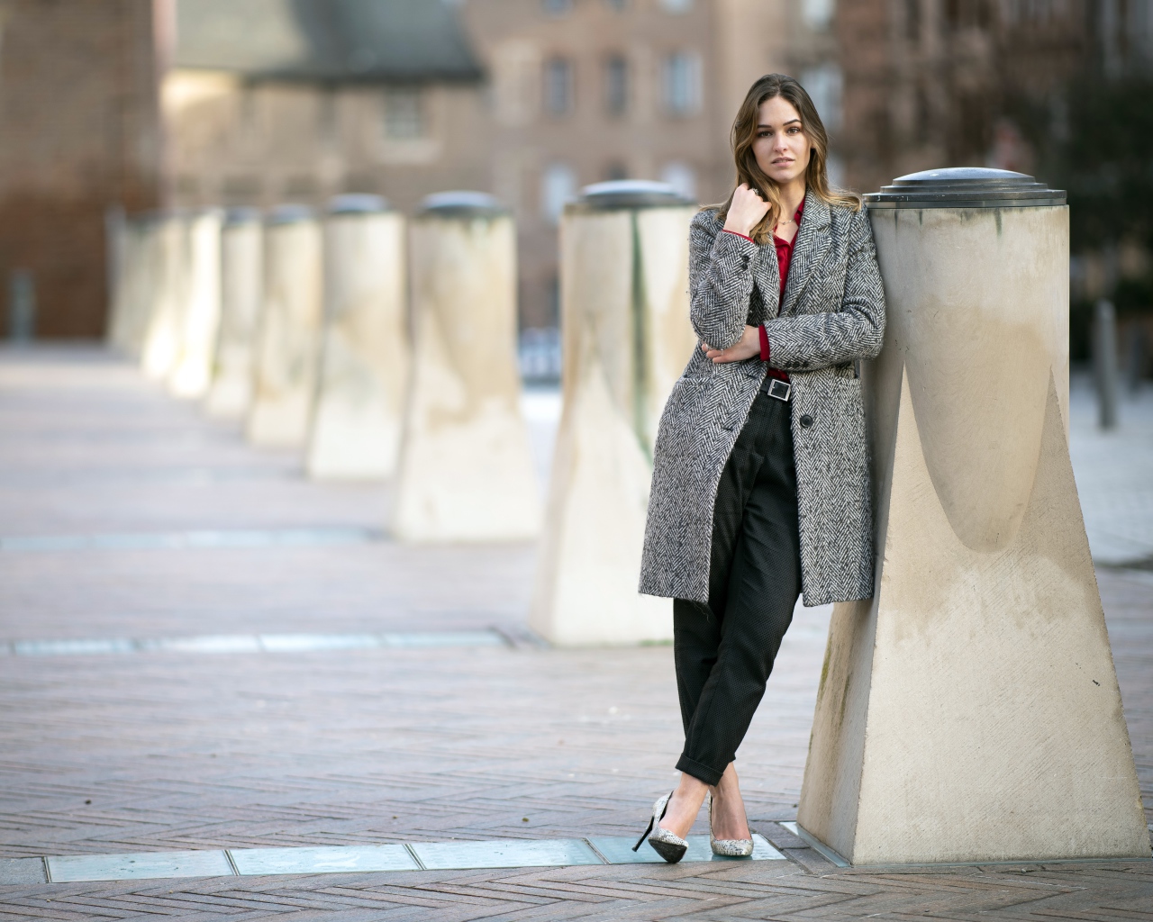 Девушка стоит в сером пальто 