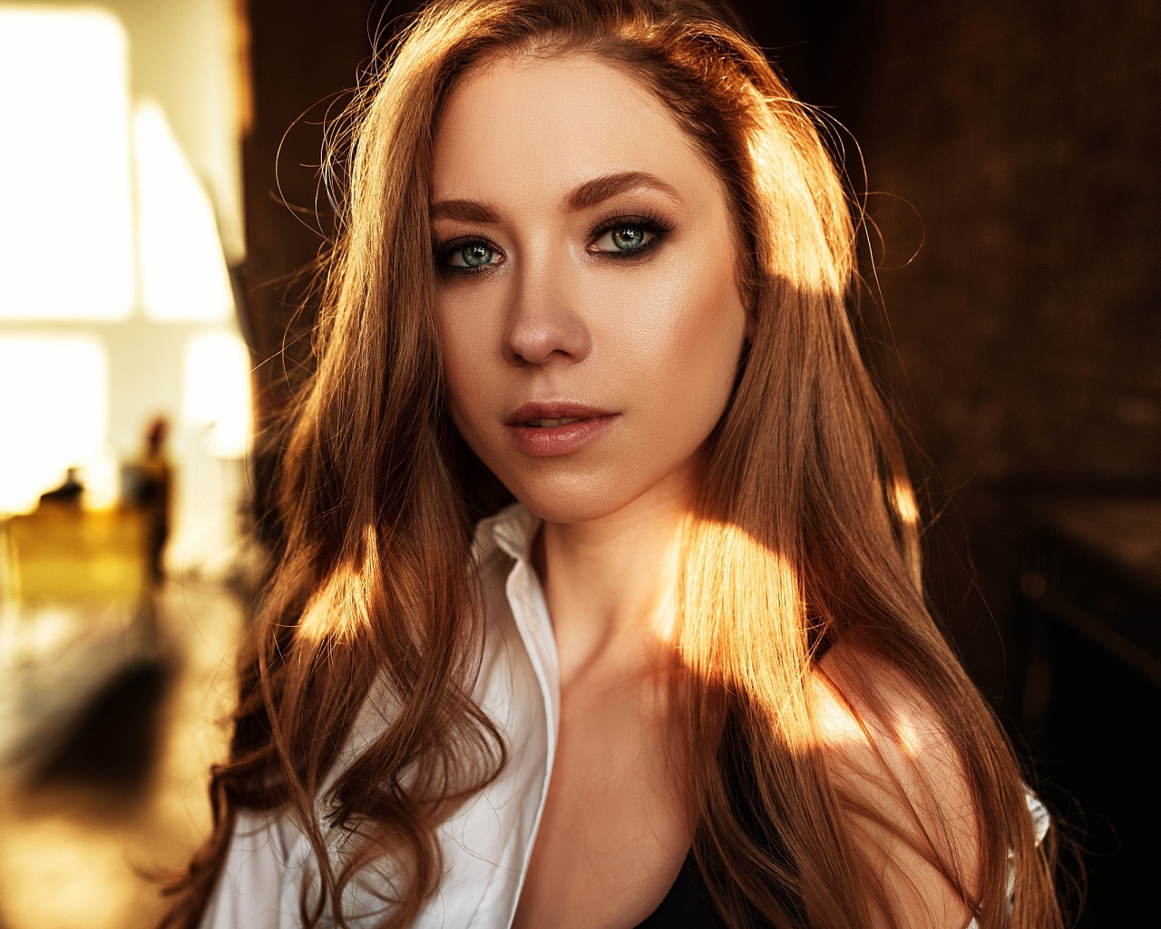 Лучи солнца нападают на волосы голубоглазой шатенки 
