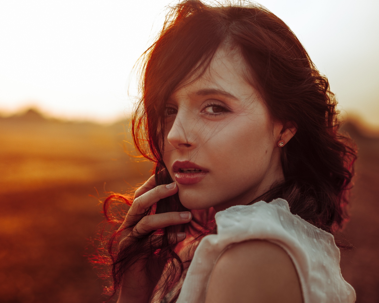 Ветер развивает волосы молодой девушки 