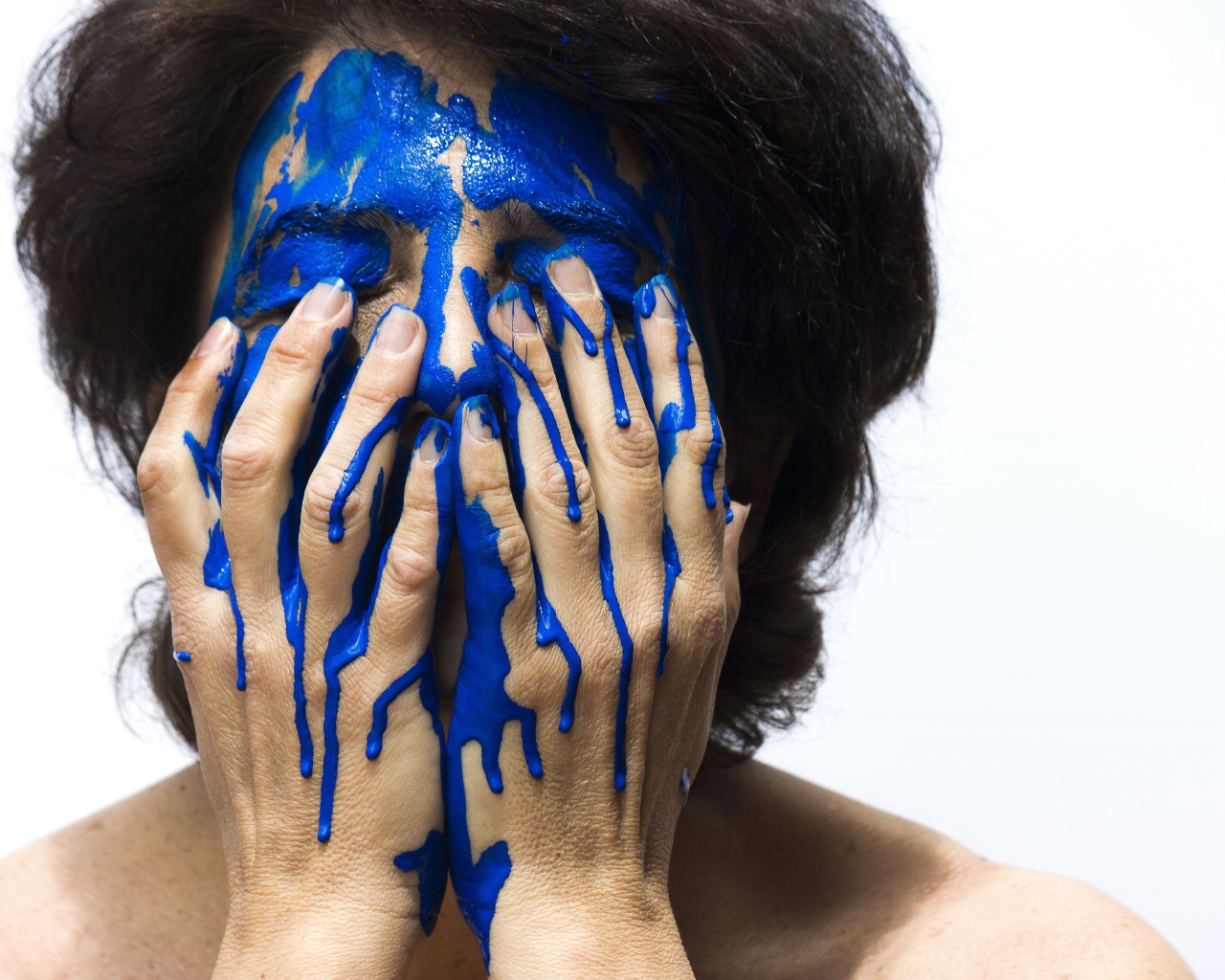Лицо и руки женщины в синей краске