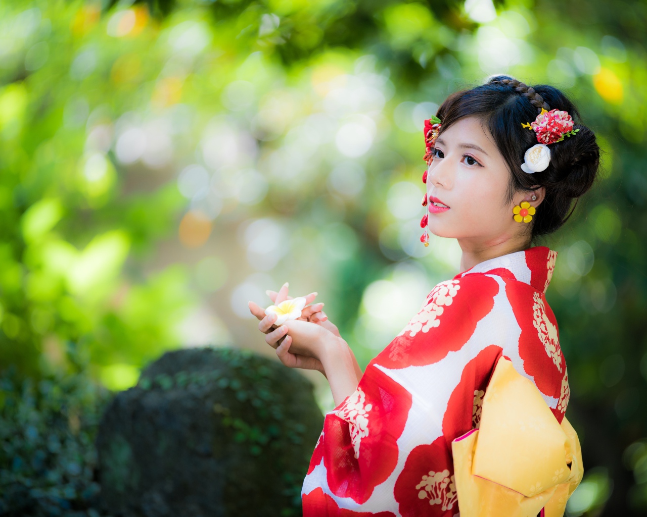 Молодая девушка азиатка в кимоно с цветами в волосах 