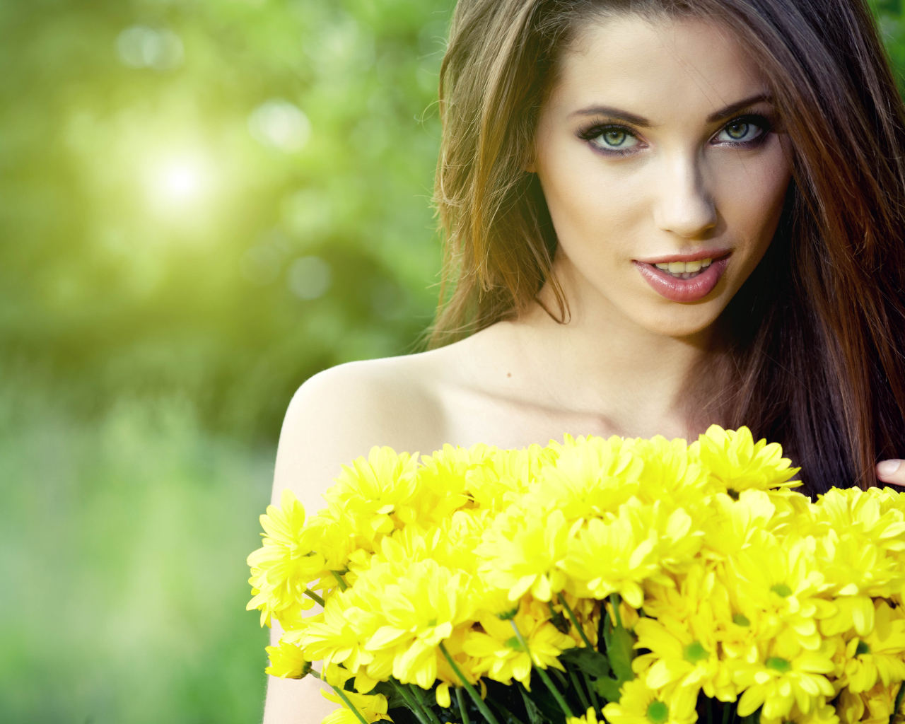 Young beautiful girl with a bouquet of yellow chrysanthemums