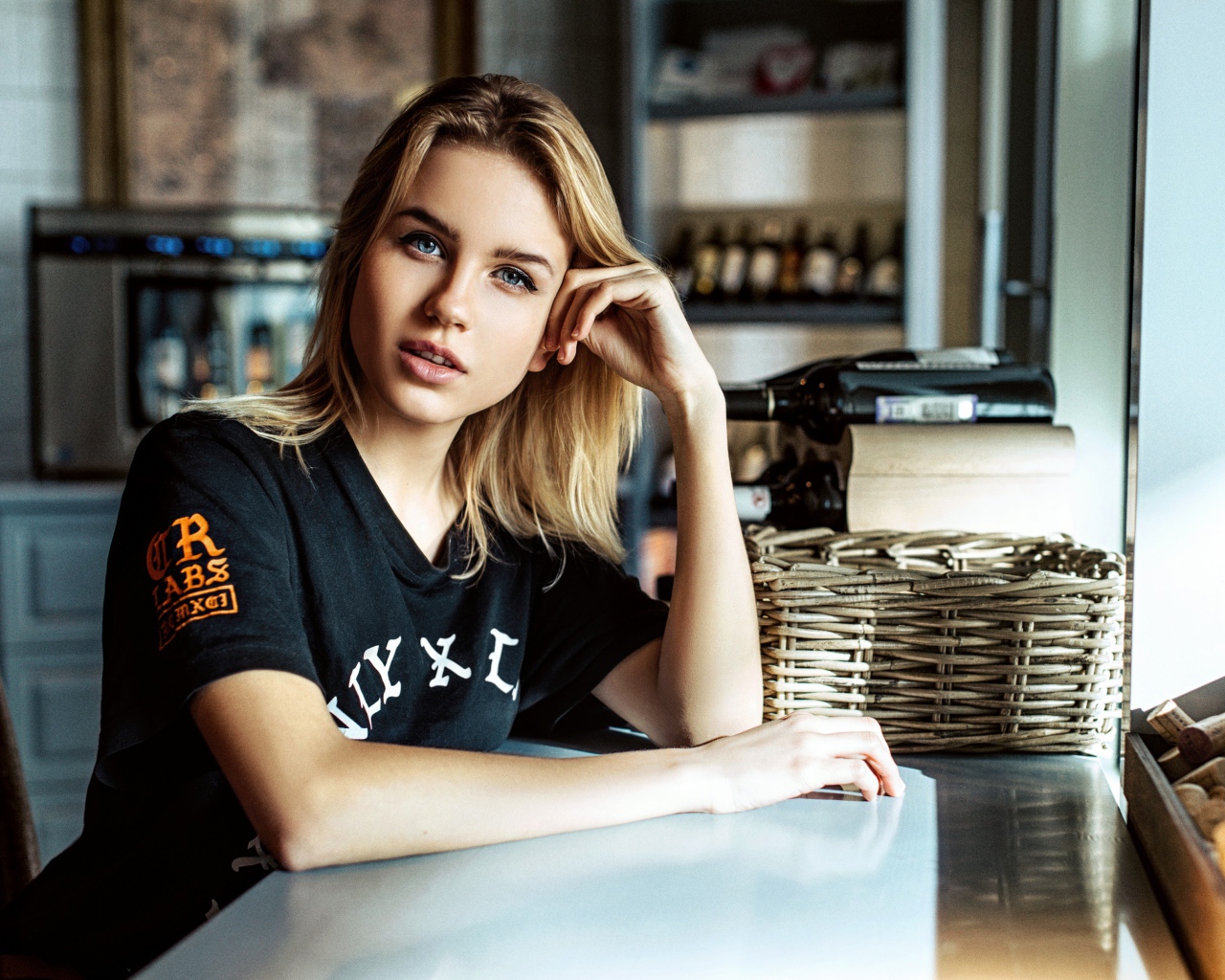 Молодая голубоглазая девушка сидит в кафе