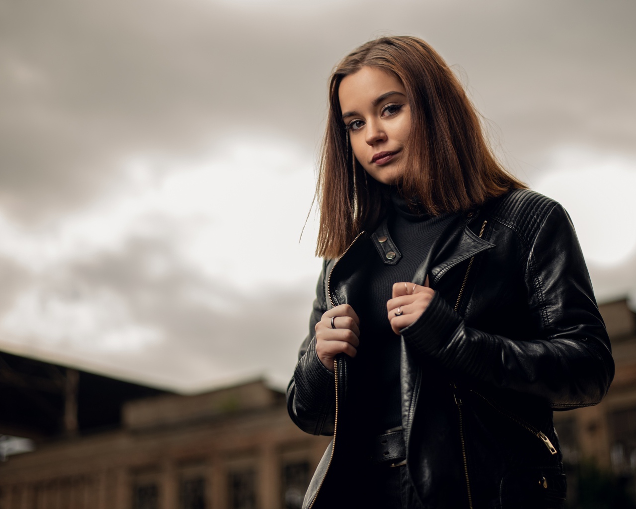 Молодая девушка в кожаной куртке на фоне грозового неба