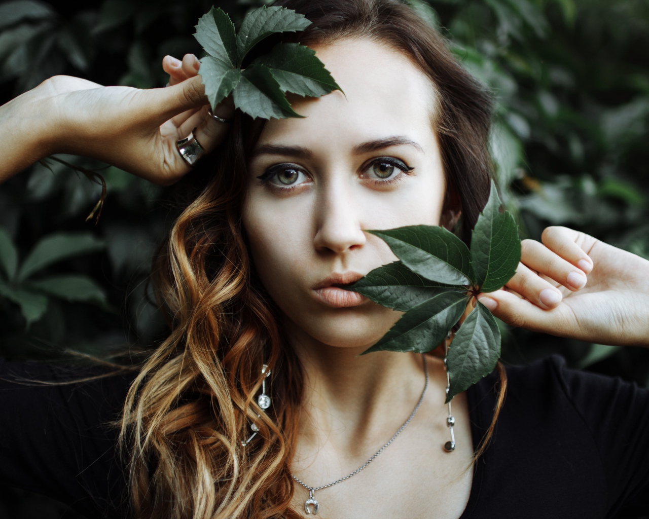 Молодая девушка с зелеными листьями в руках 
