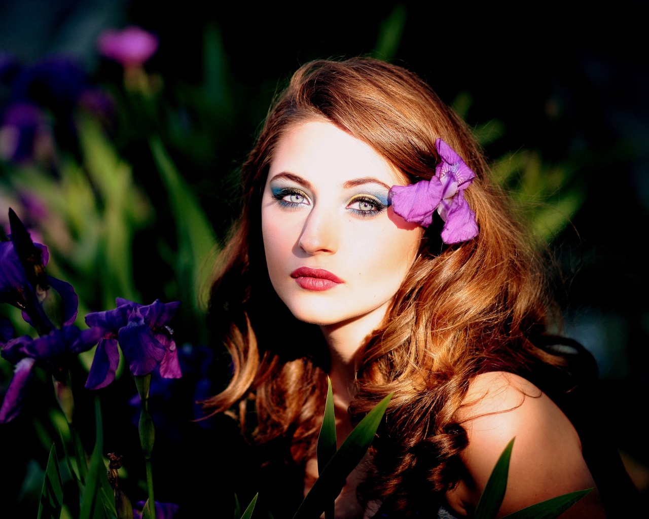 Молодая девушка с фиолетовым цветком ириса в волосах