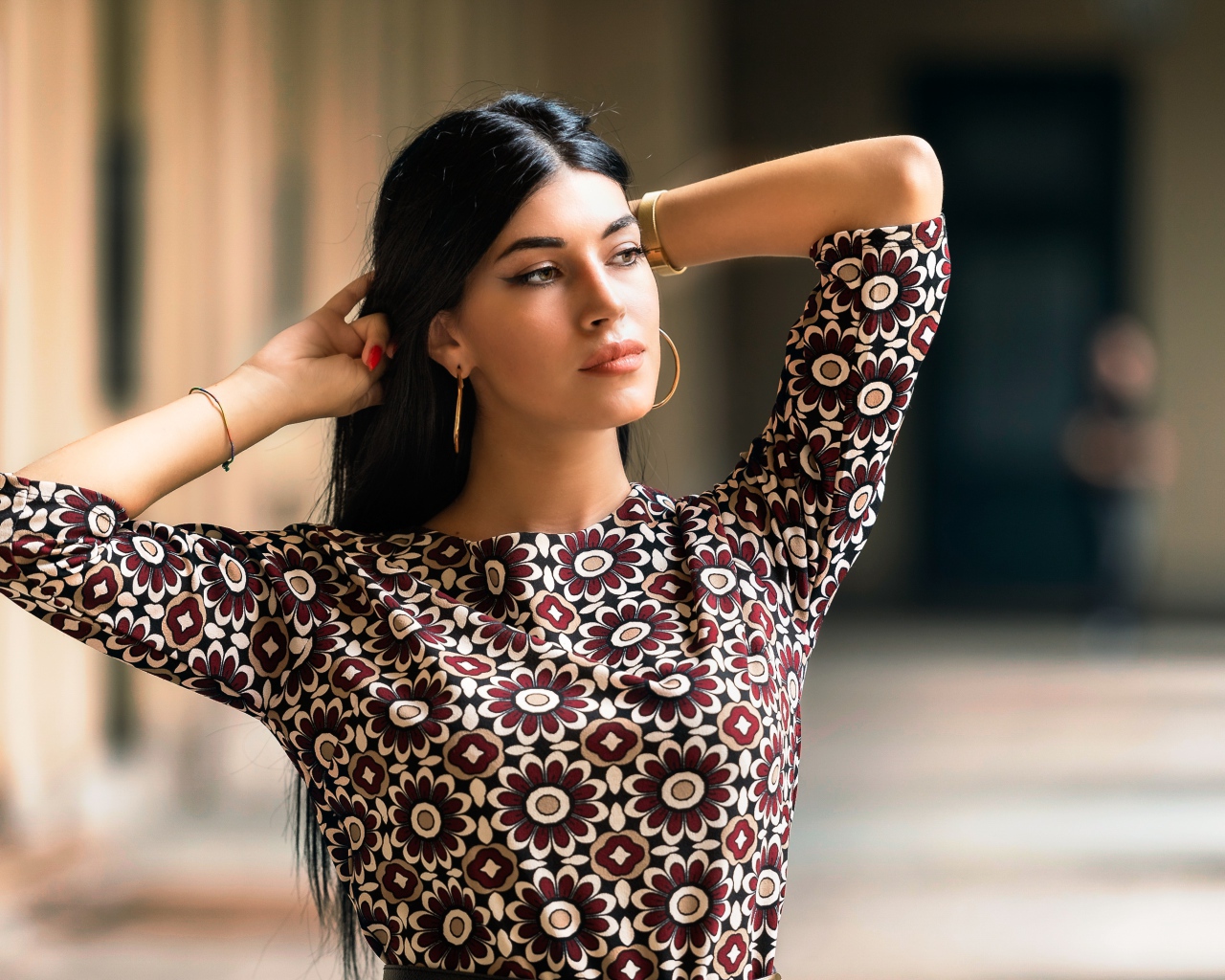 Молодая длинноволосая шатенка с руками в волосах