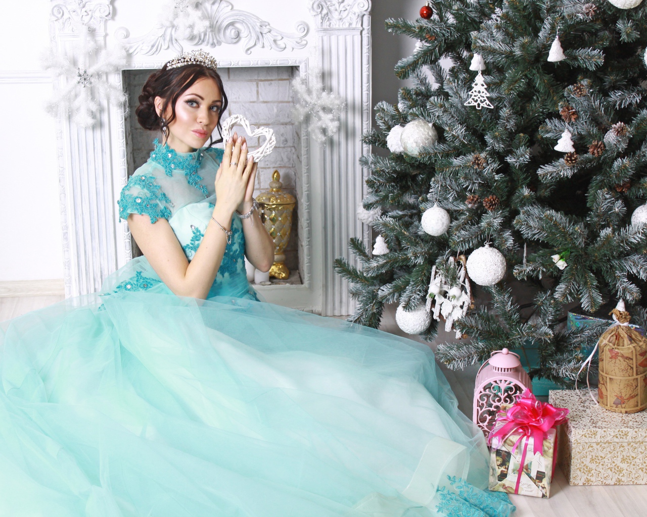 Молодая девушка в красивом голубом платье у новогодней елки