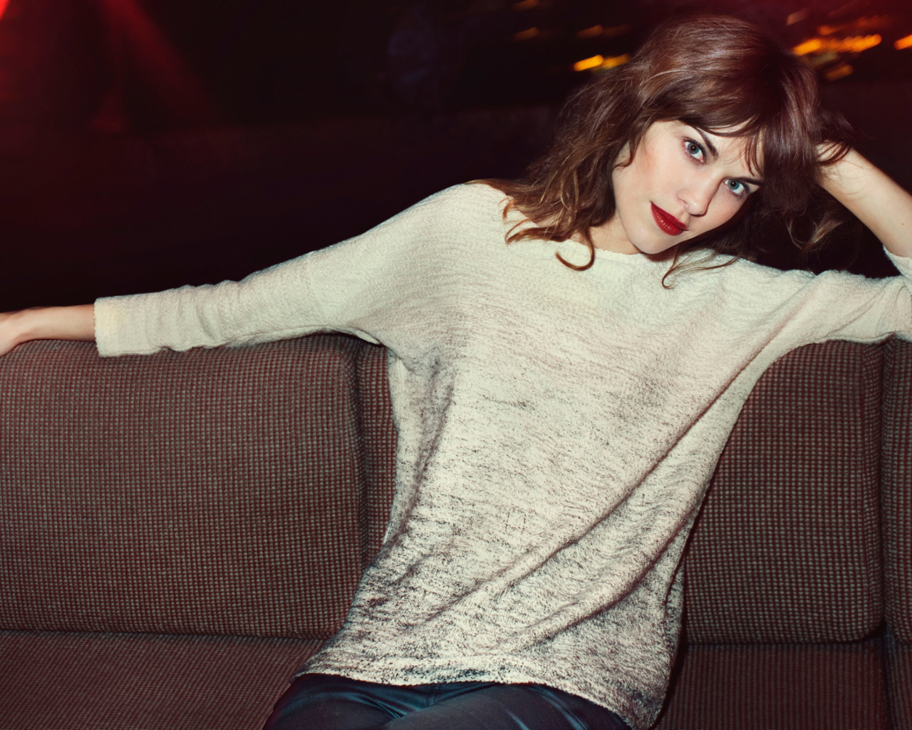 Красивая девушка модель Алекса Чанг сидит на диване