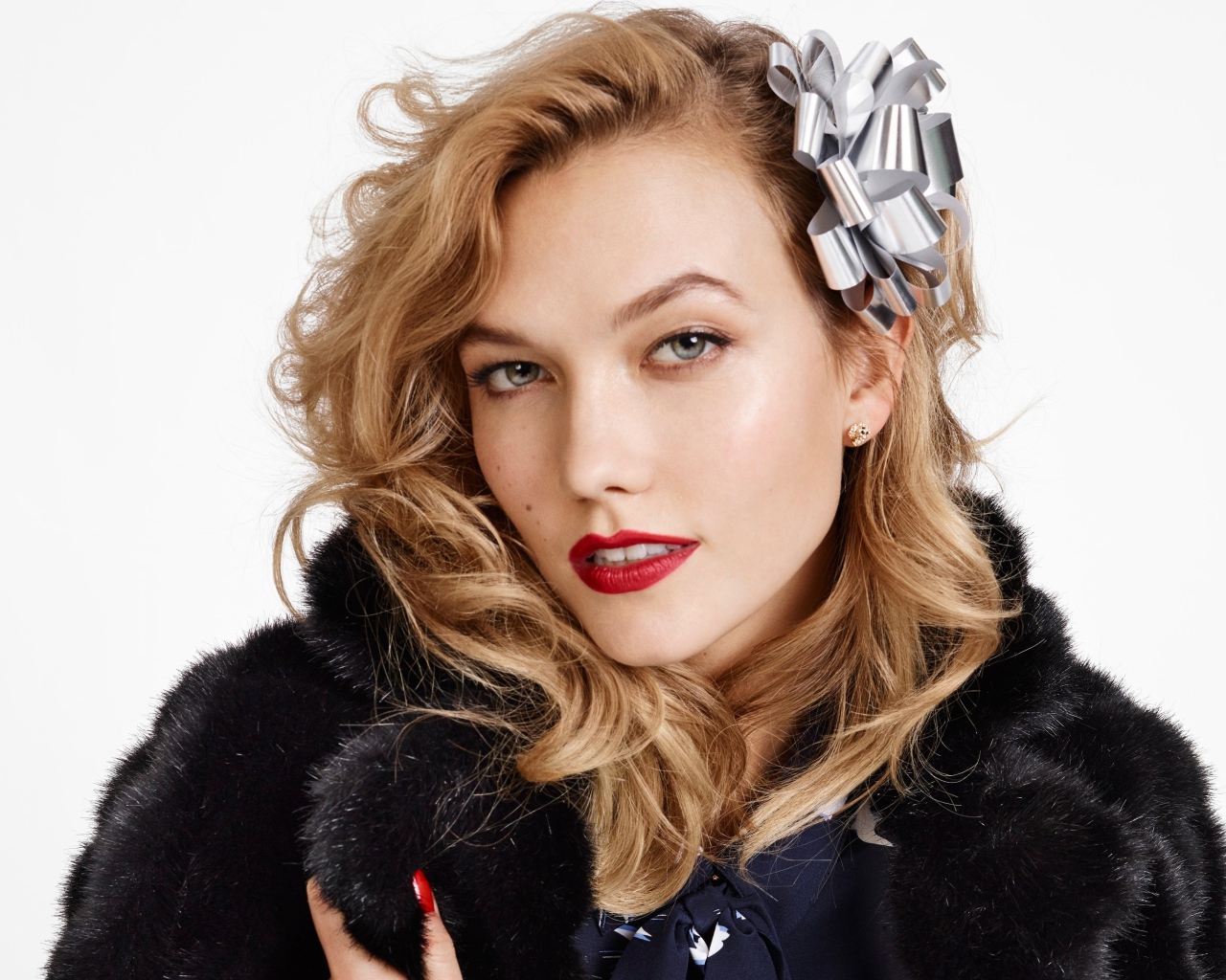 Модель Карли Клосс в черной шубе на белом фоне