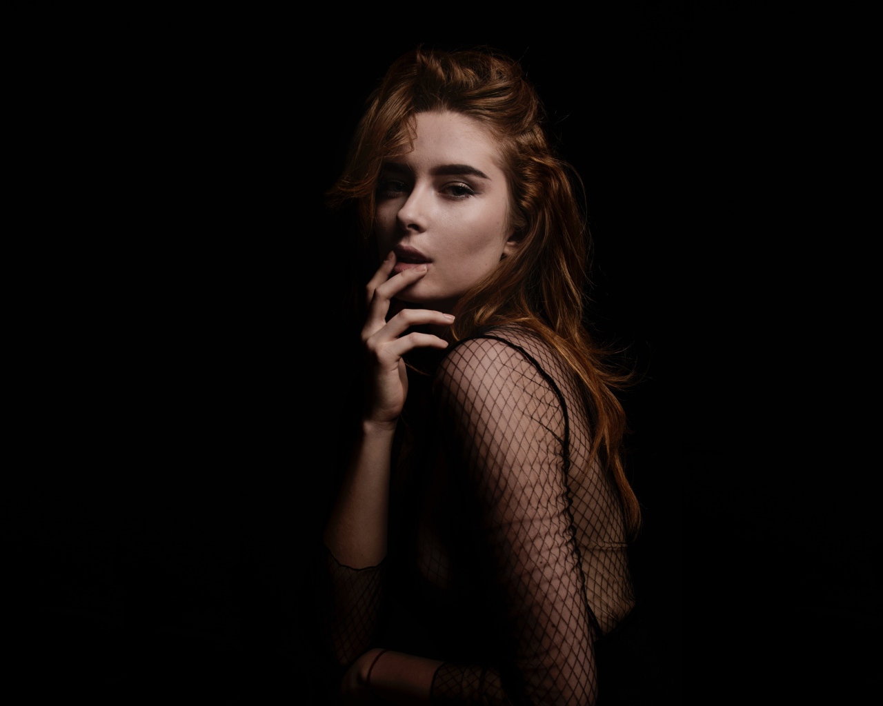 Рыжеволосая девушка модель на черном фоне