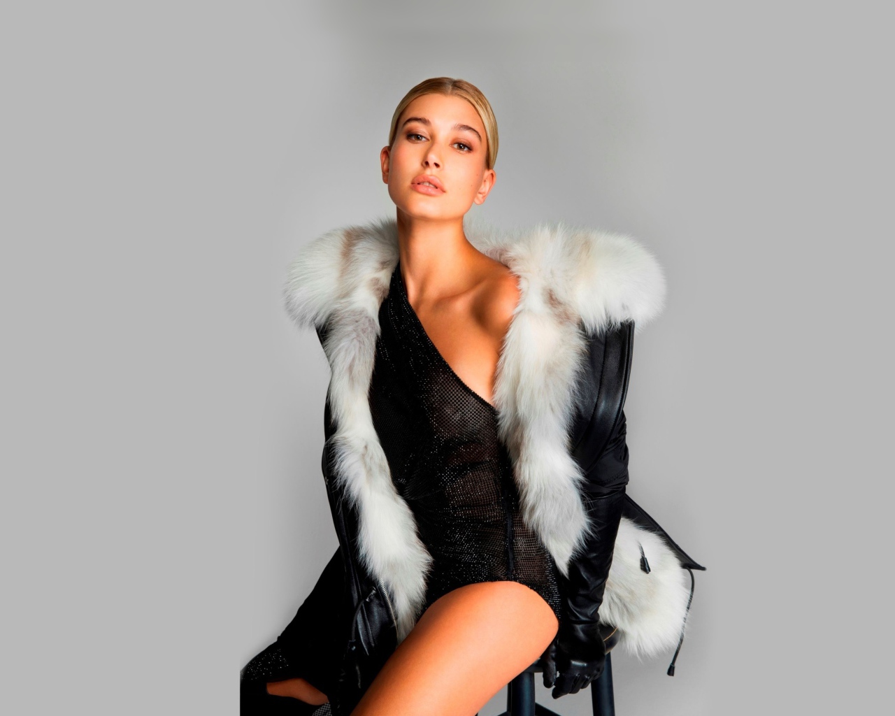 Эффектная модель Хейли Болдуин сидит на стуле на сером фоне