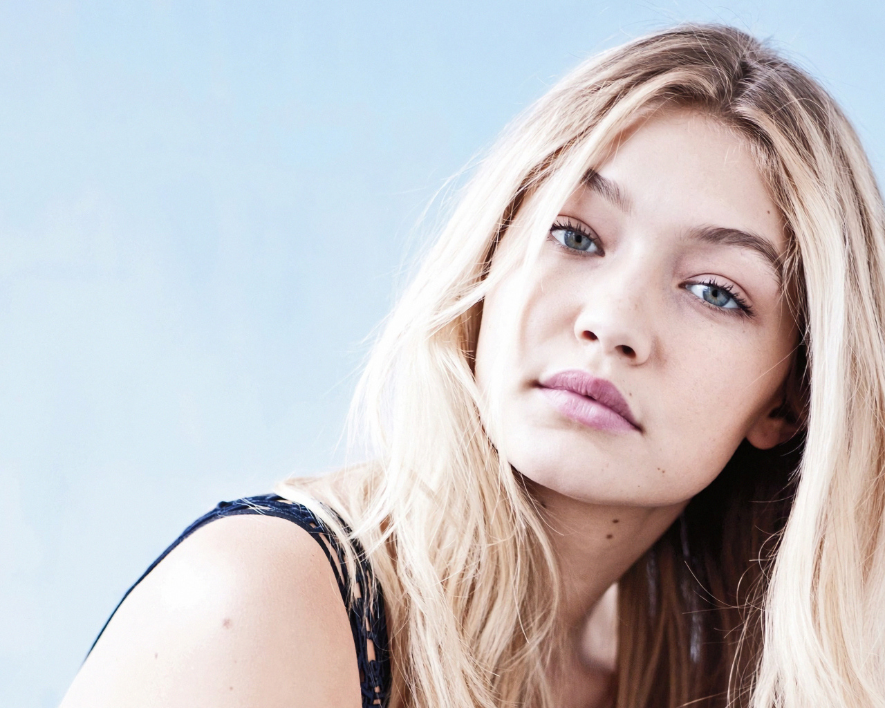 Молодая блондинка, модель Джиджи Хадид на сером фоне