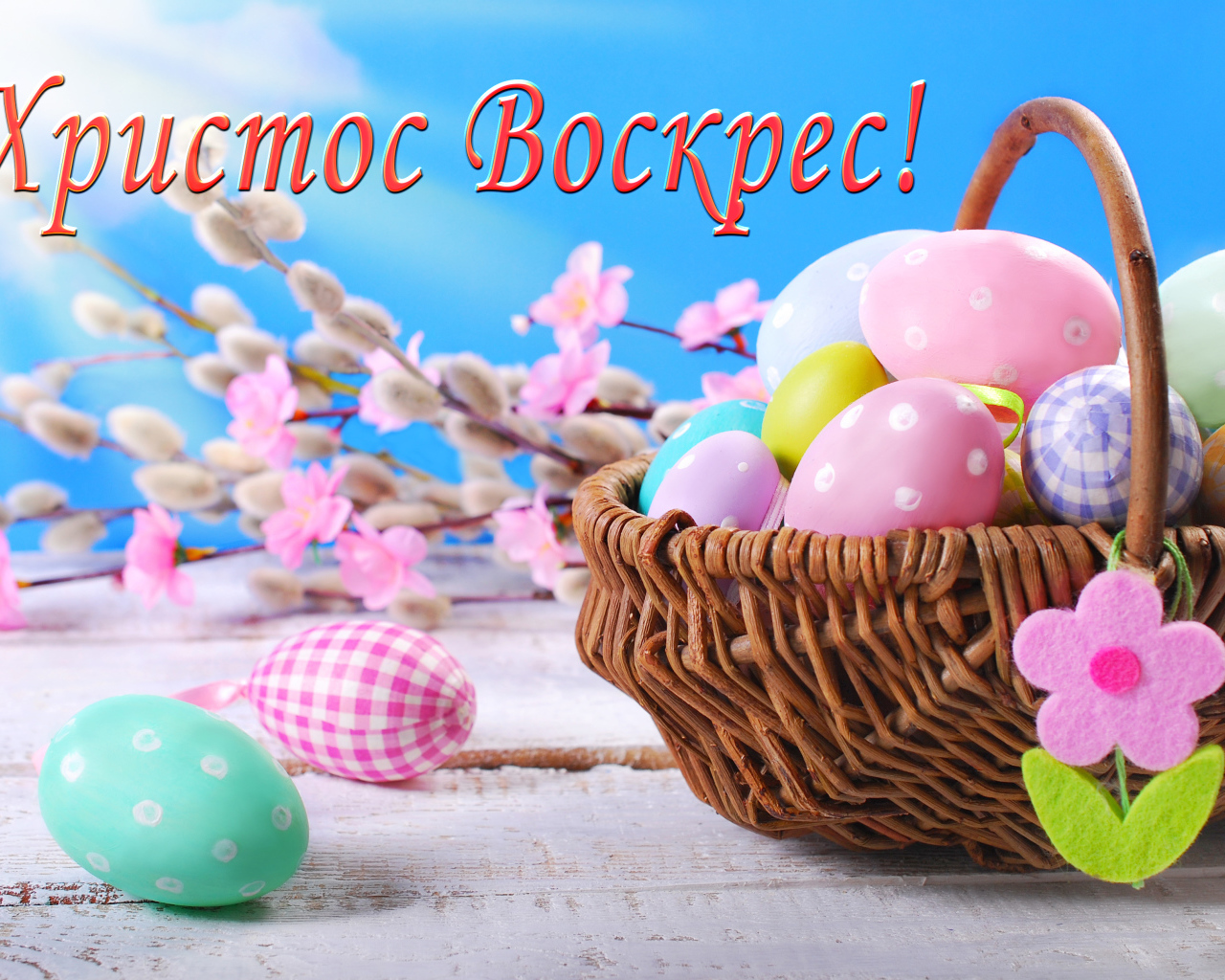 Корзина крашеных яиц на голубом фоне с надписью Христос Воскрес! 