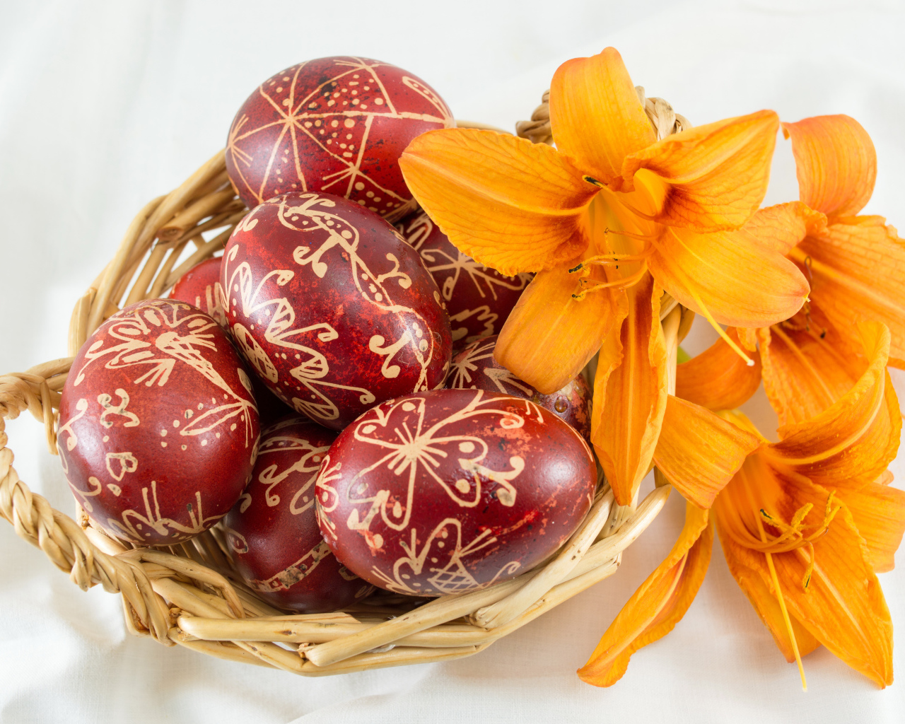 Красивые крашеные пасхальные яйца на белом фоне с цветами лилии
