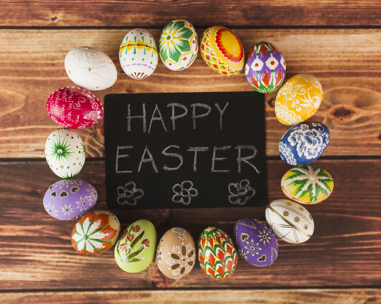 Надпись на английском Счастливой Пасхи на столе с крашеными яйцами