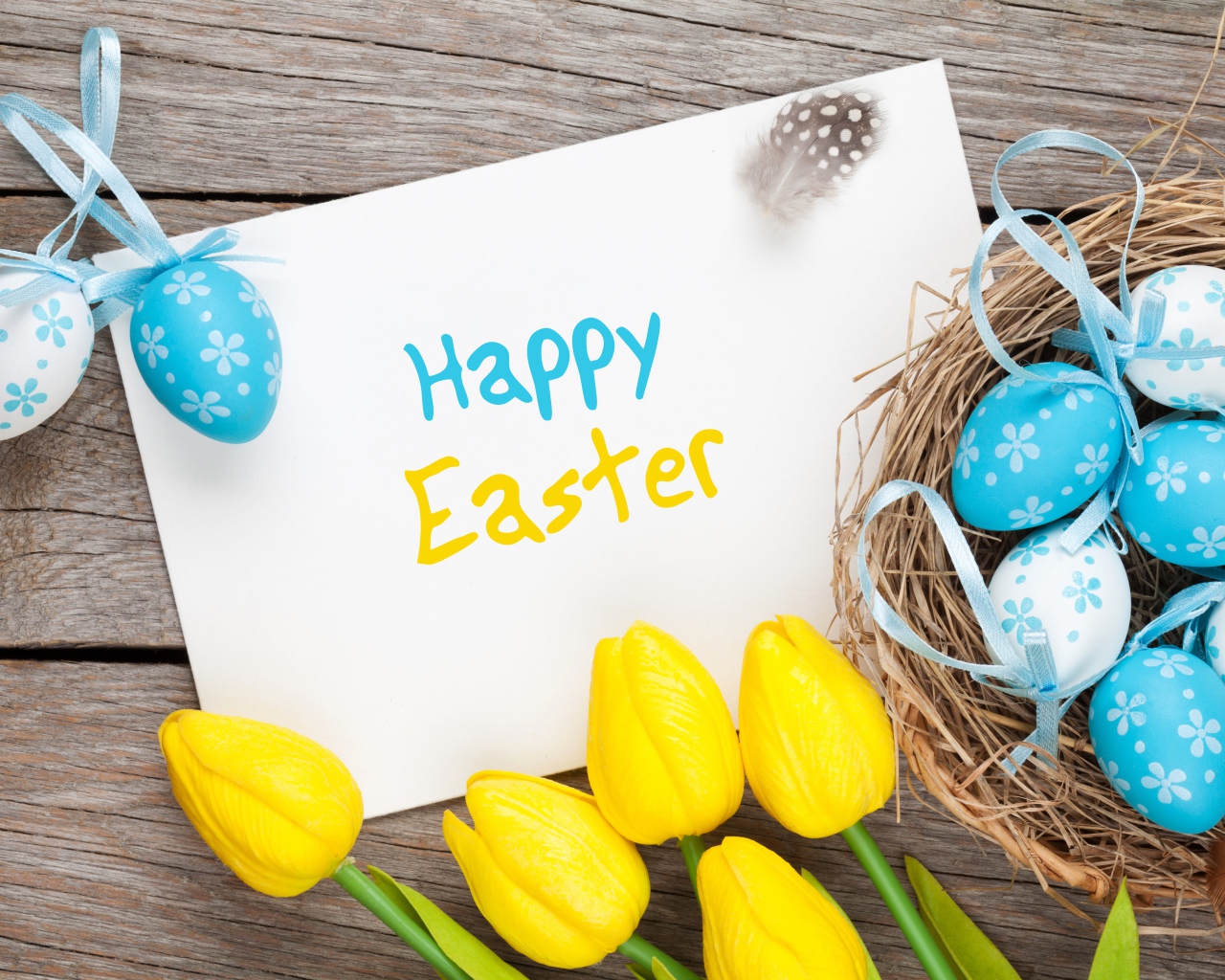 Надпись на белом листе Happy Easter с букетом желтых тюльпанов и крашенными яйцами