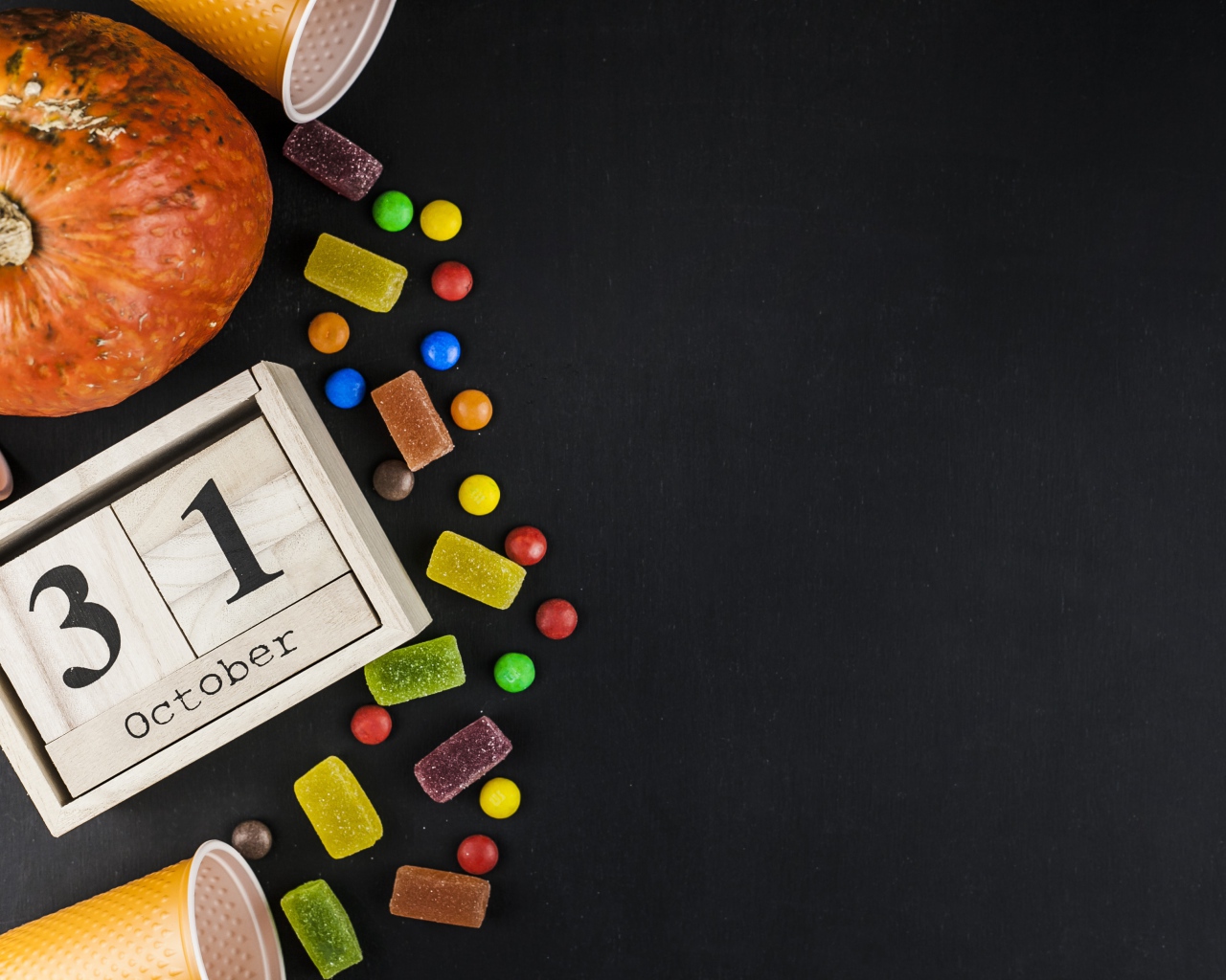 Конфеты, тыква и календарь на сером фоне на Хэллоуин