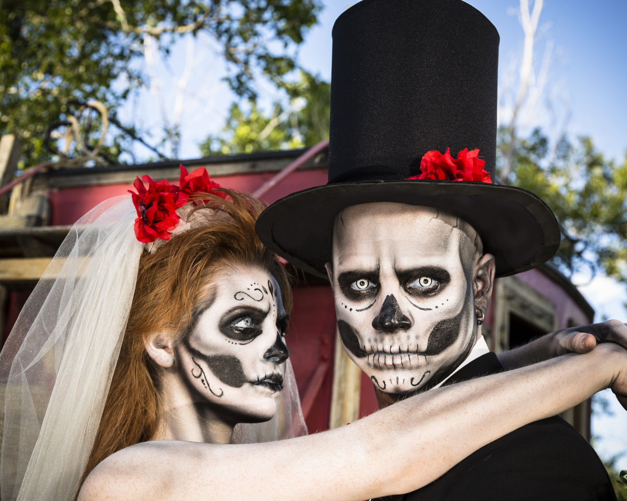 Пара жених и невеста с масками с грима на лице на Хэллоуин 