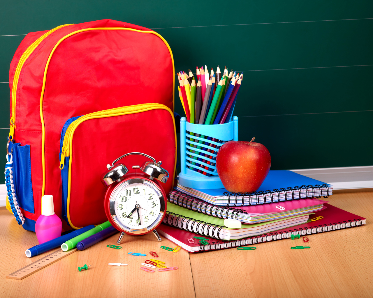 Рюкзак, тетради, карандаши, будильник и яблоко на День знаний 1 сентября