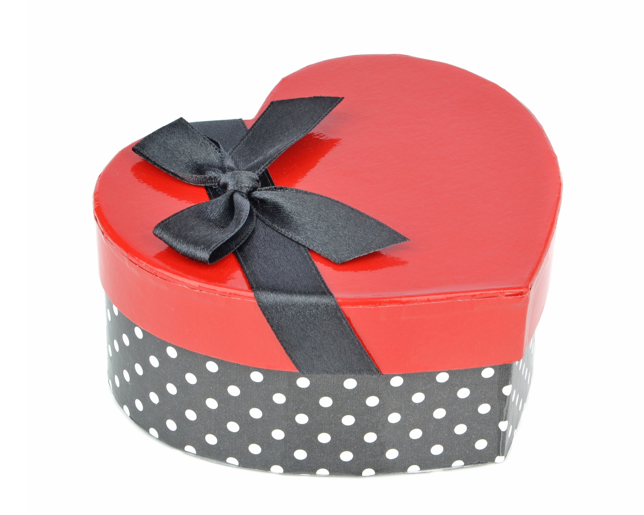 Красивая коробка в форме сердца с черным бантом на белом фоне
