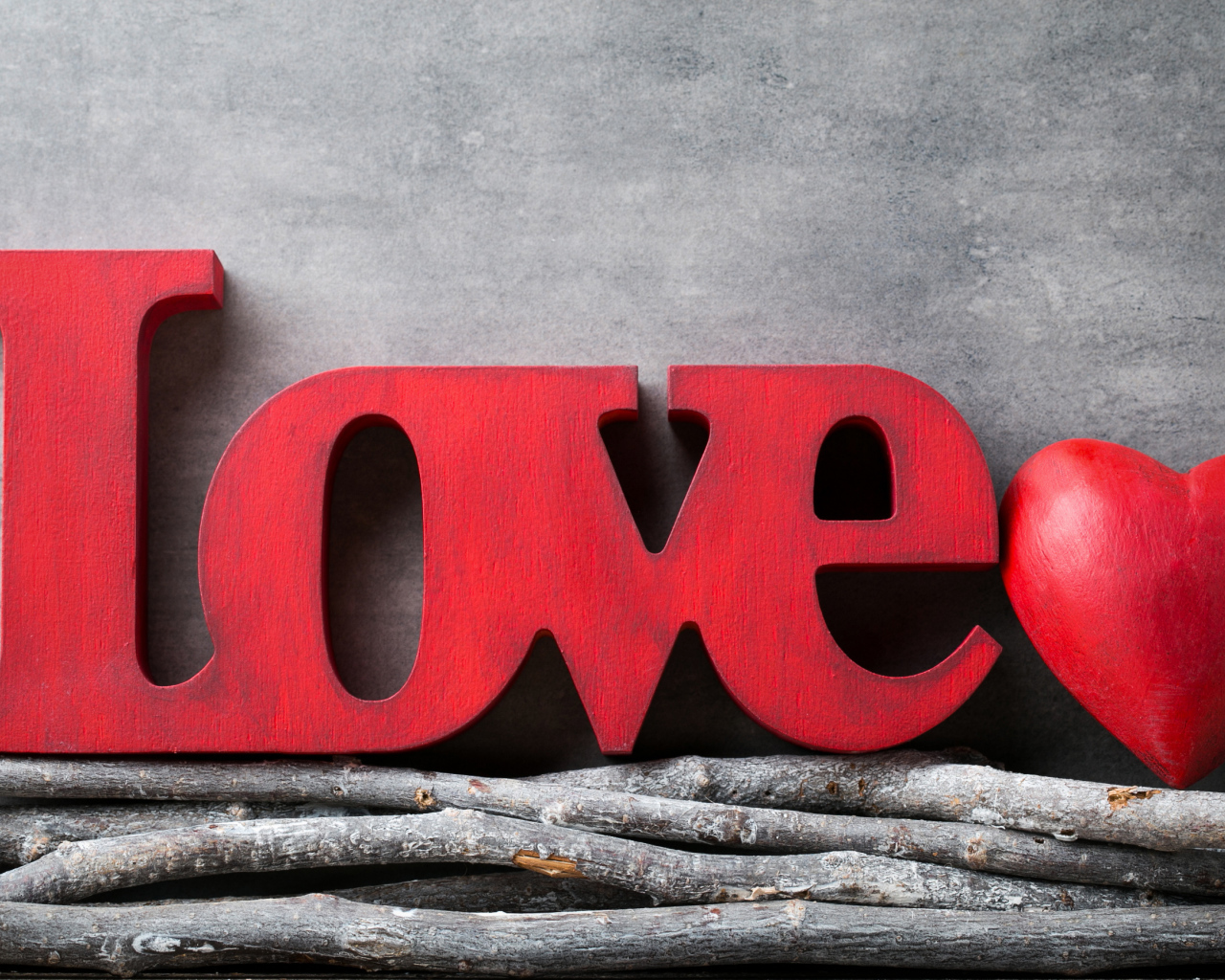 Большая надпись любовь на английском на фоне серой стены 