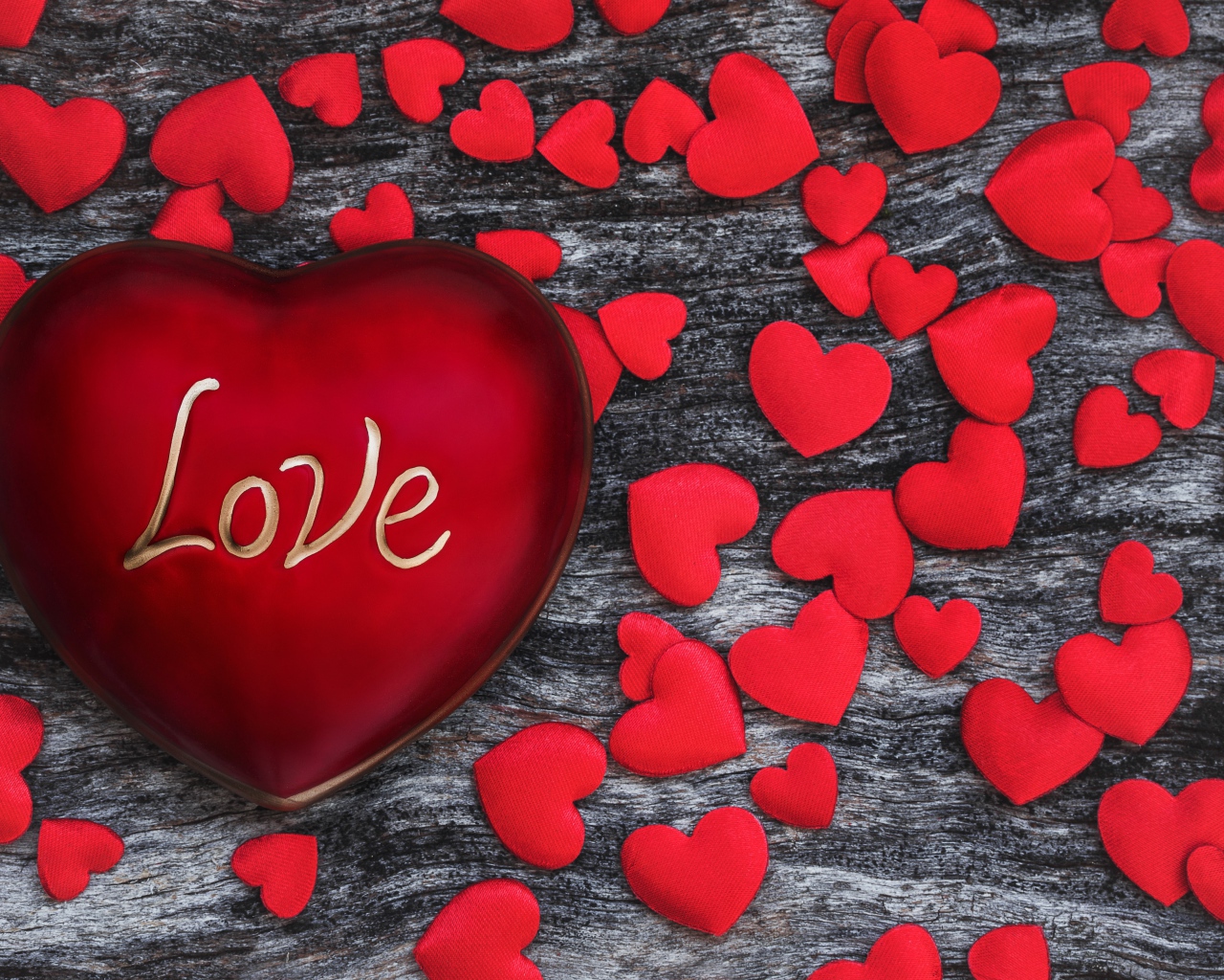 Большое красное сердце на деревянном фоне с маленькими сердечками