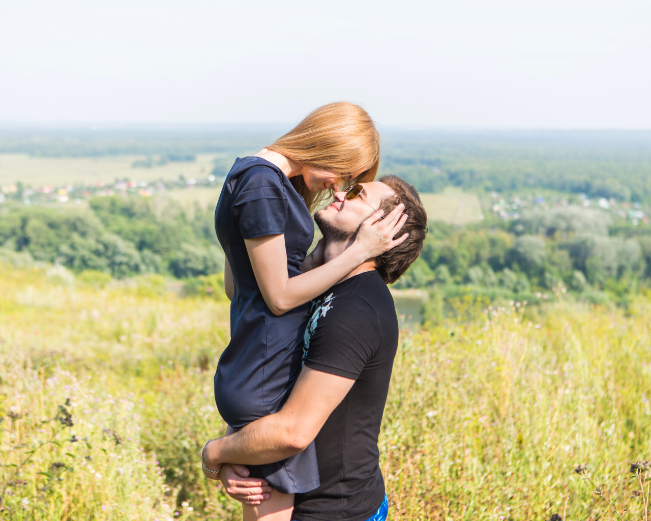 Влюбленная пара обнимается на поле 