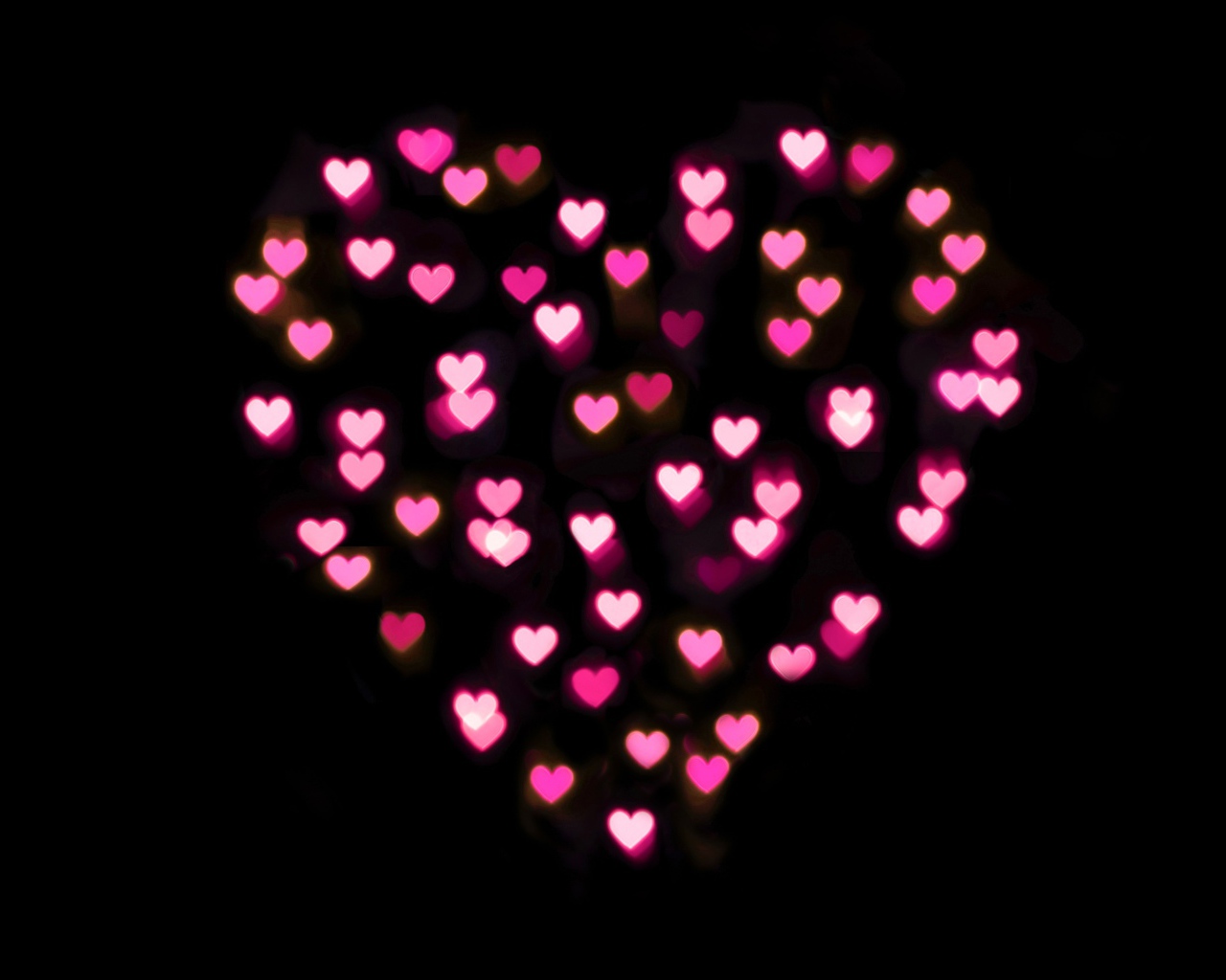 Сердце из маленьких розовых сердечек на черном фоне