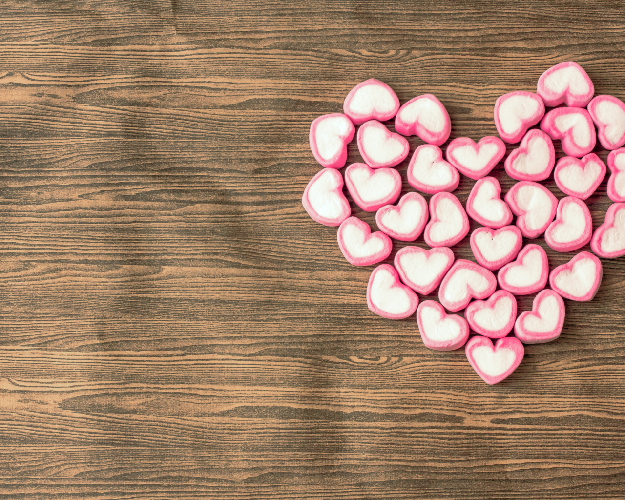 Сердце из конфет на деревянном столе