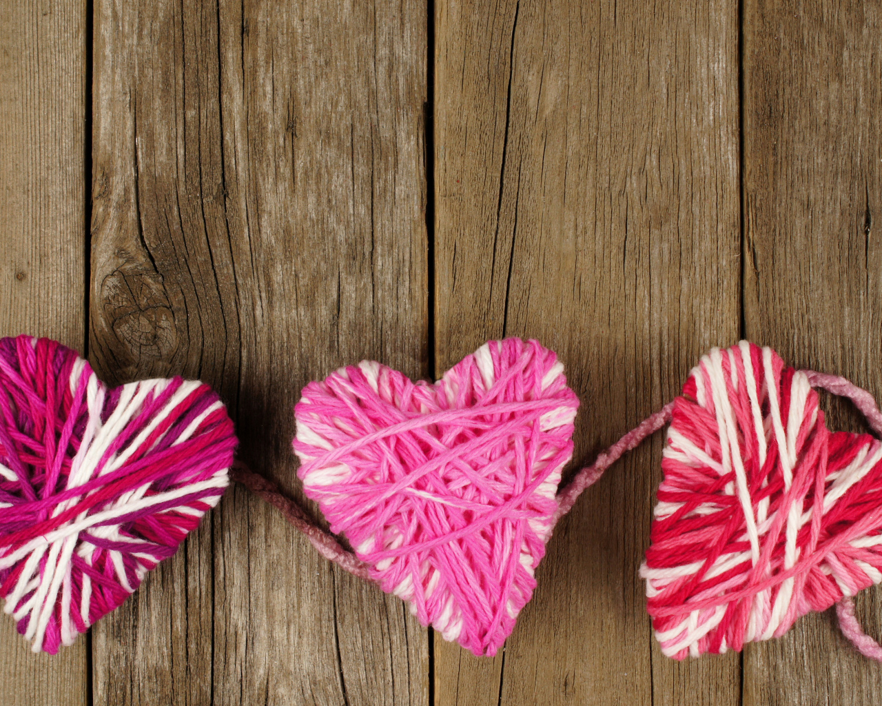 Сердца из ниток на деревянном столе