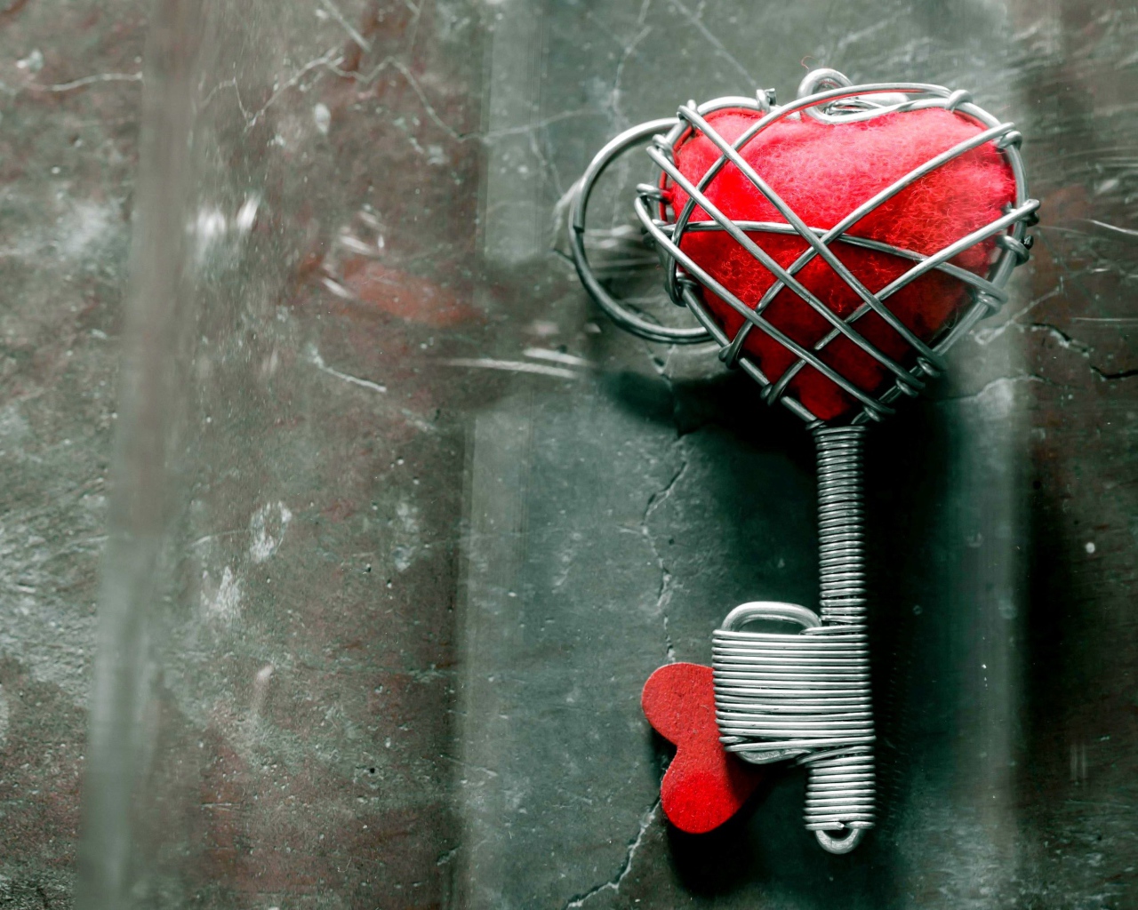 Ключ с красным сердцем на сером столе