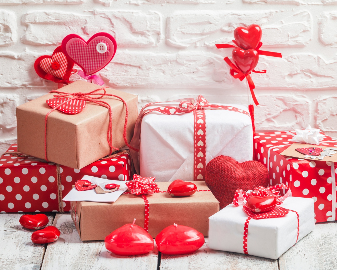 Много  подарочных коробок с сердечками на фоне стены