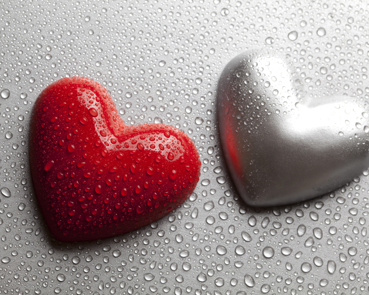 Красное и серое сердце на сером фоне в каплях воды