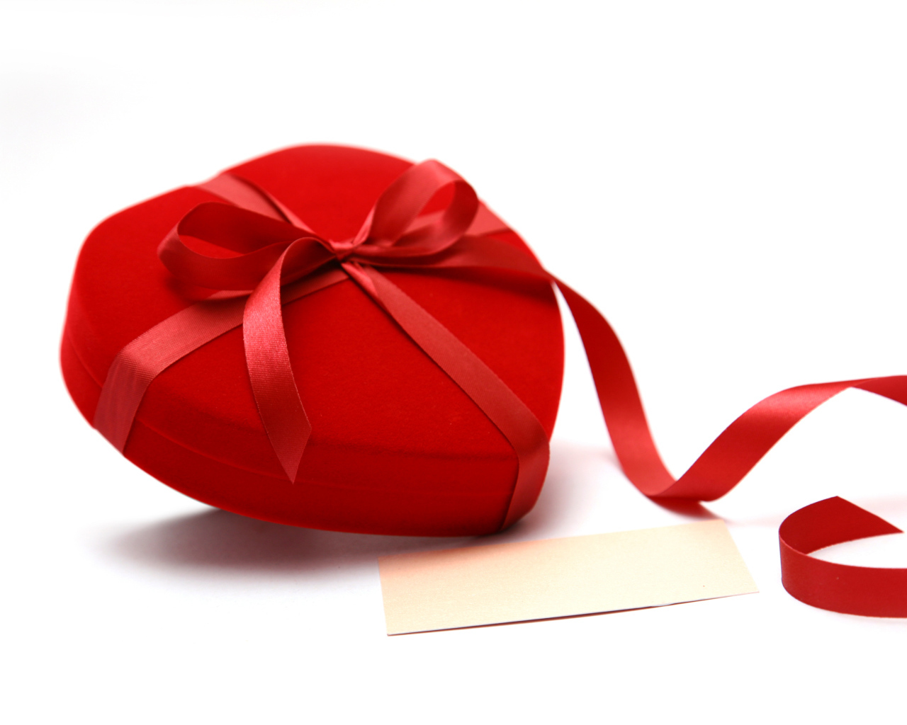 Красная коробка для ювелирных изделий в форме сердца на белом фоне 