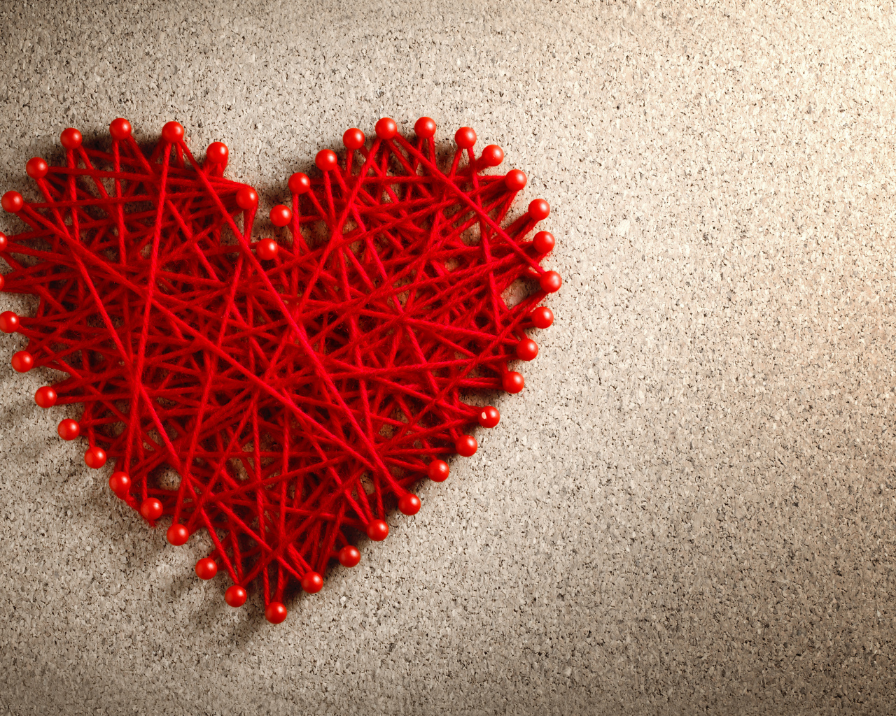 Сердце из красных нитей и невидимок на сером фоне