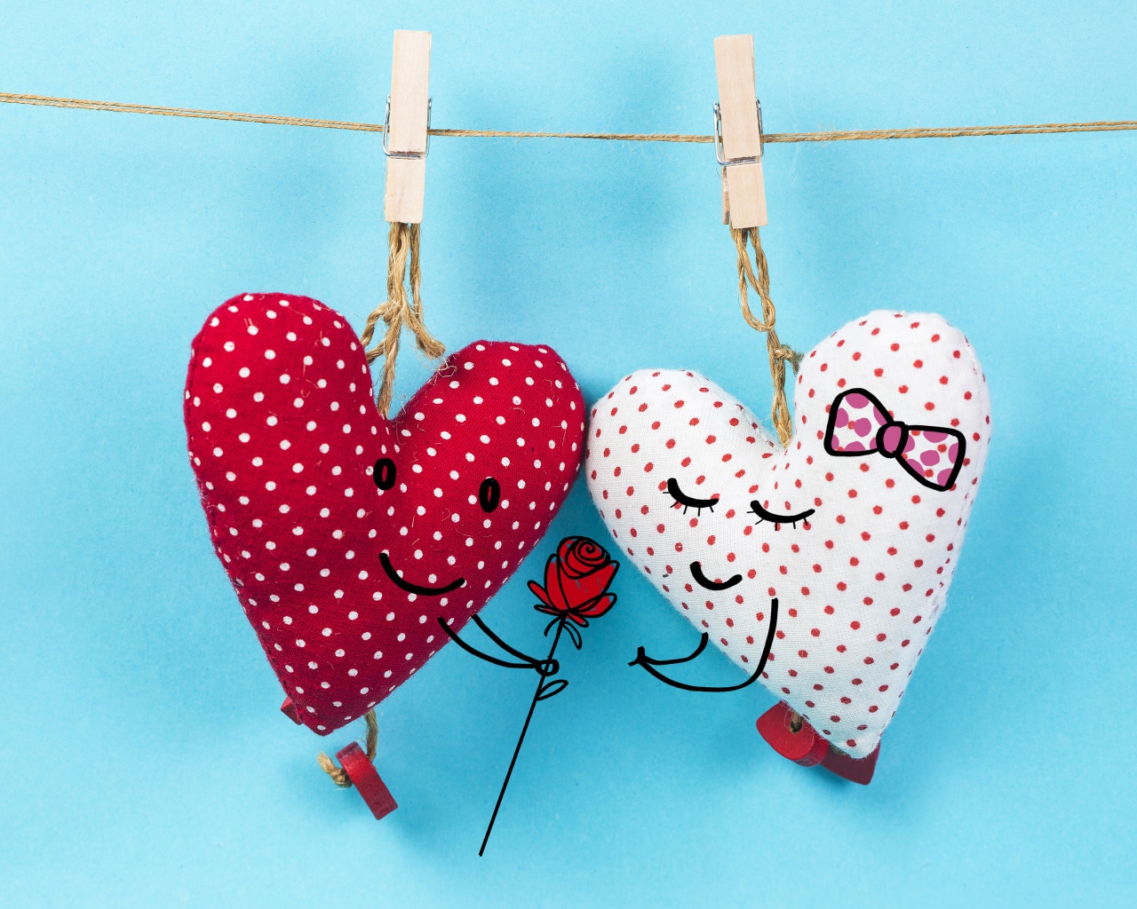 Два сердечка на прищепках на веревке на голубом фоне