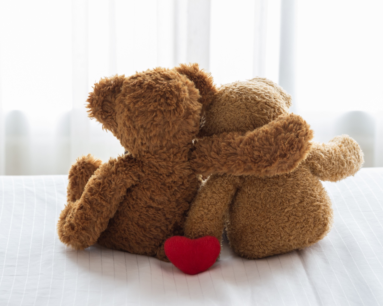 Два влюбленных плюшевых медвежонка на кровати