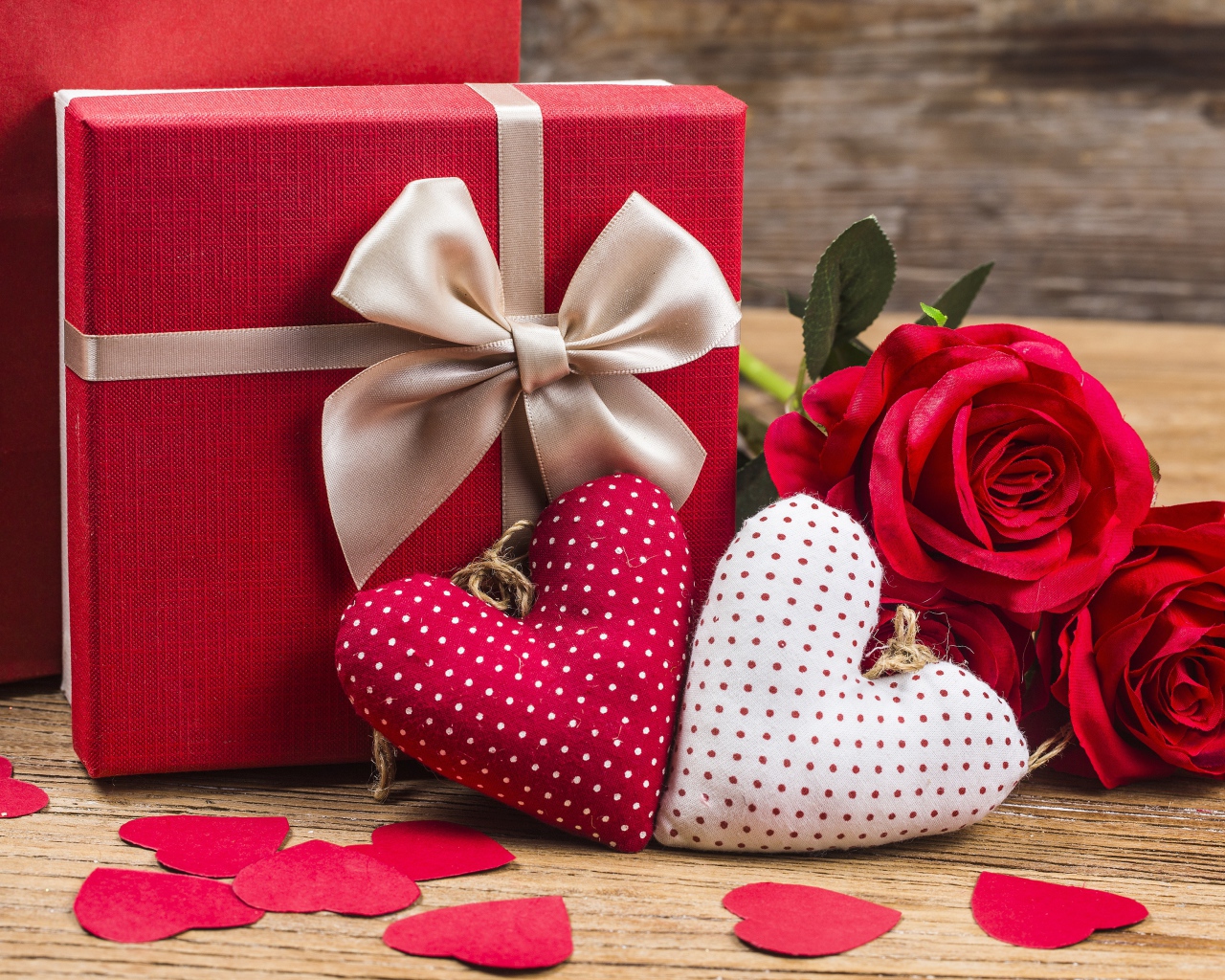 Два мягких сердечка на столе с подарком и розами для любимой