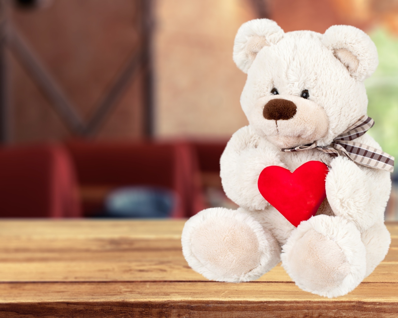 Белый плюшевый мишка с красным сердцем