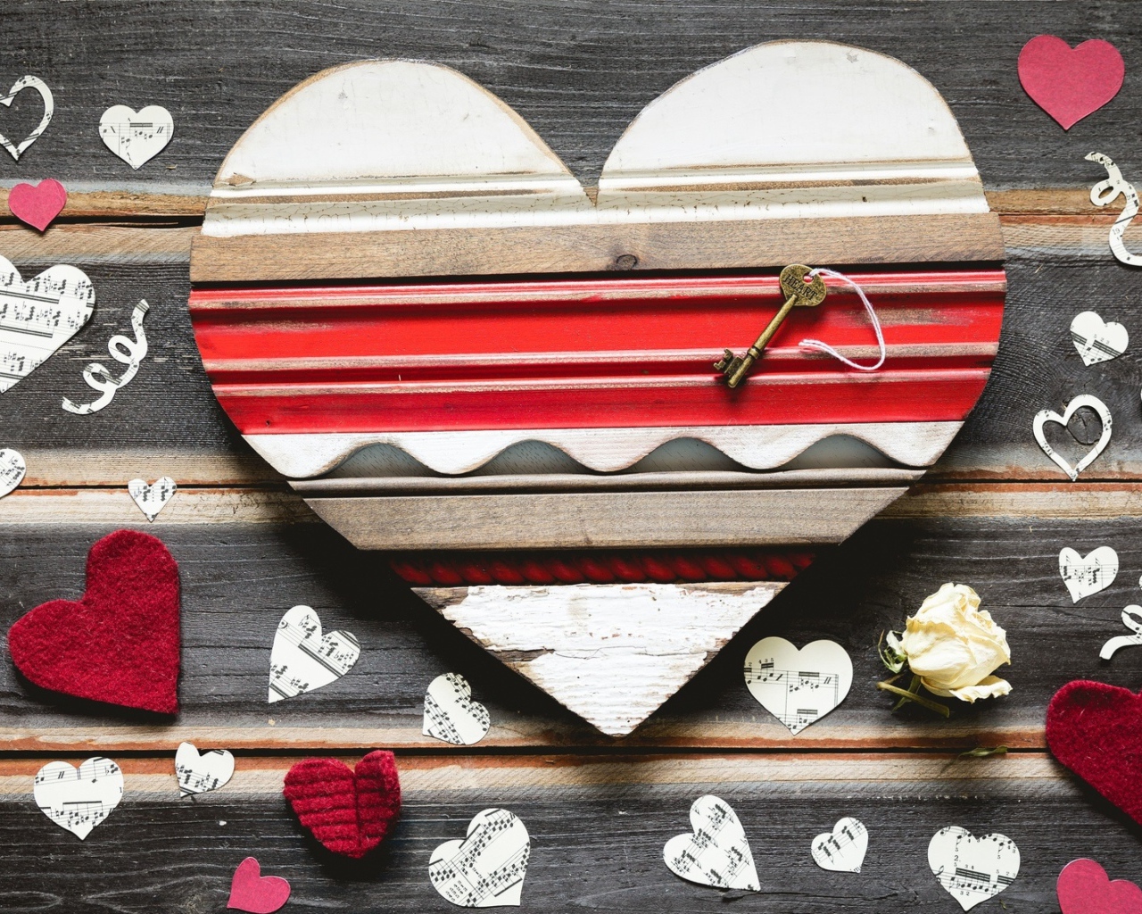 Деревянное сердце с бумажными сердечками на столе