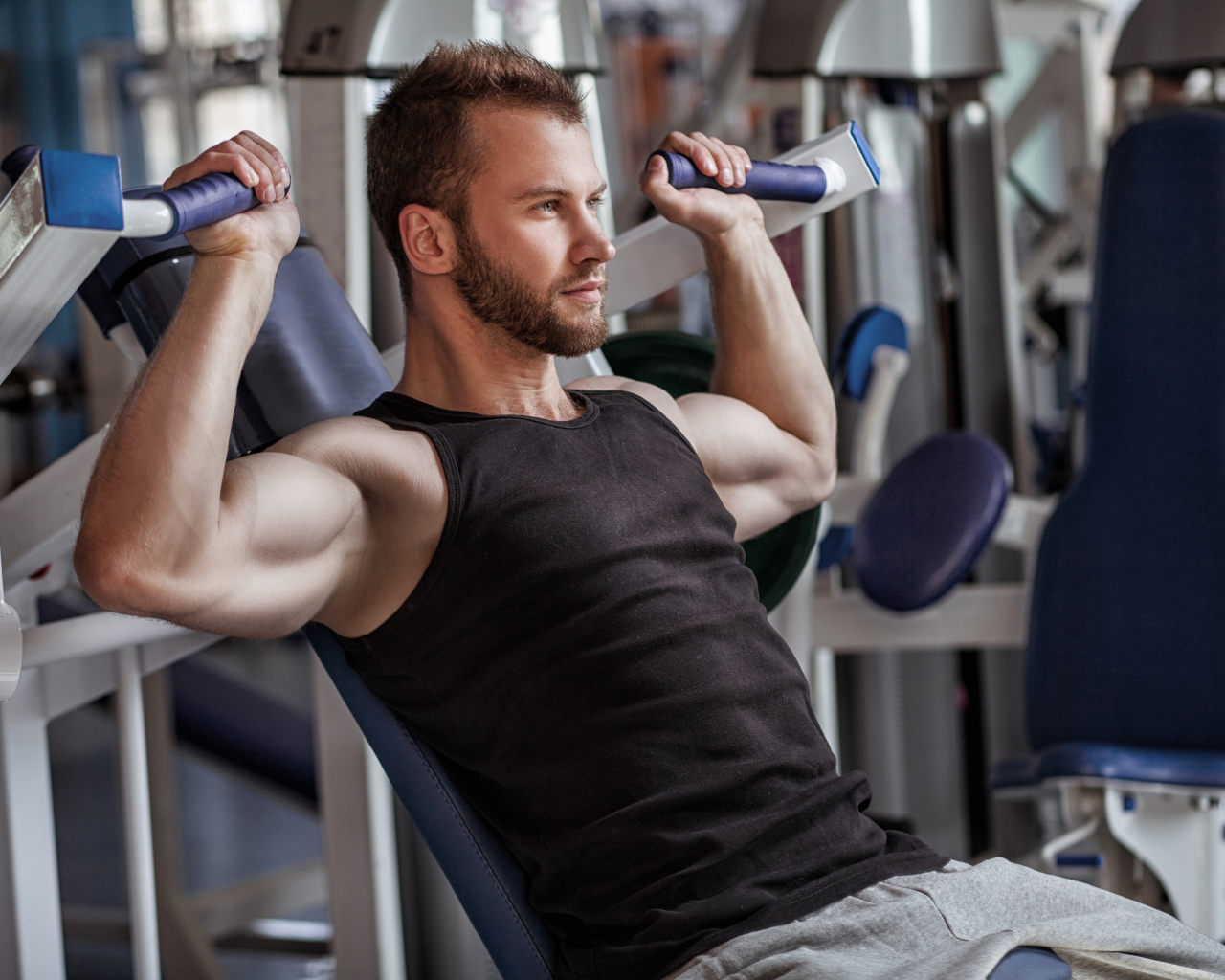 Накаченный мужчина занимается в спортзале