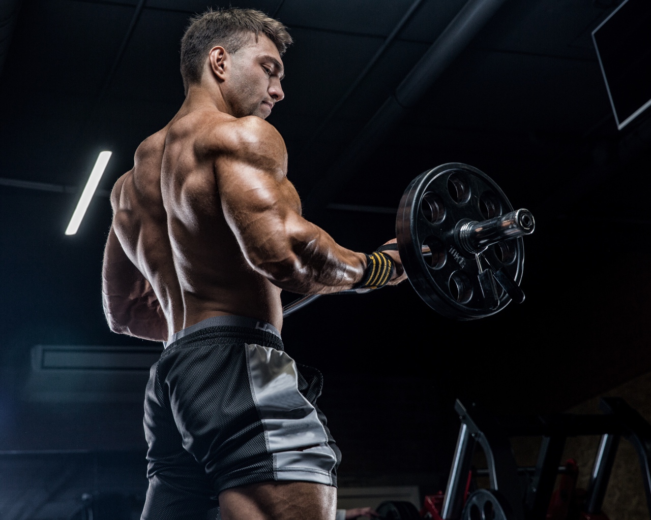 Спортивный накаченный мужчина со штангой в руках 