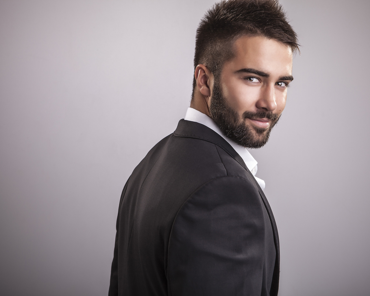 Красивый мужчина модель с бородой на сером фоне