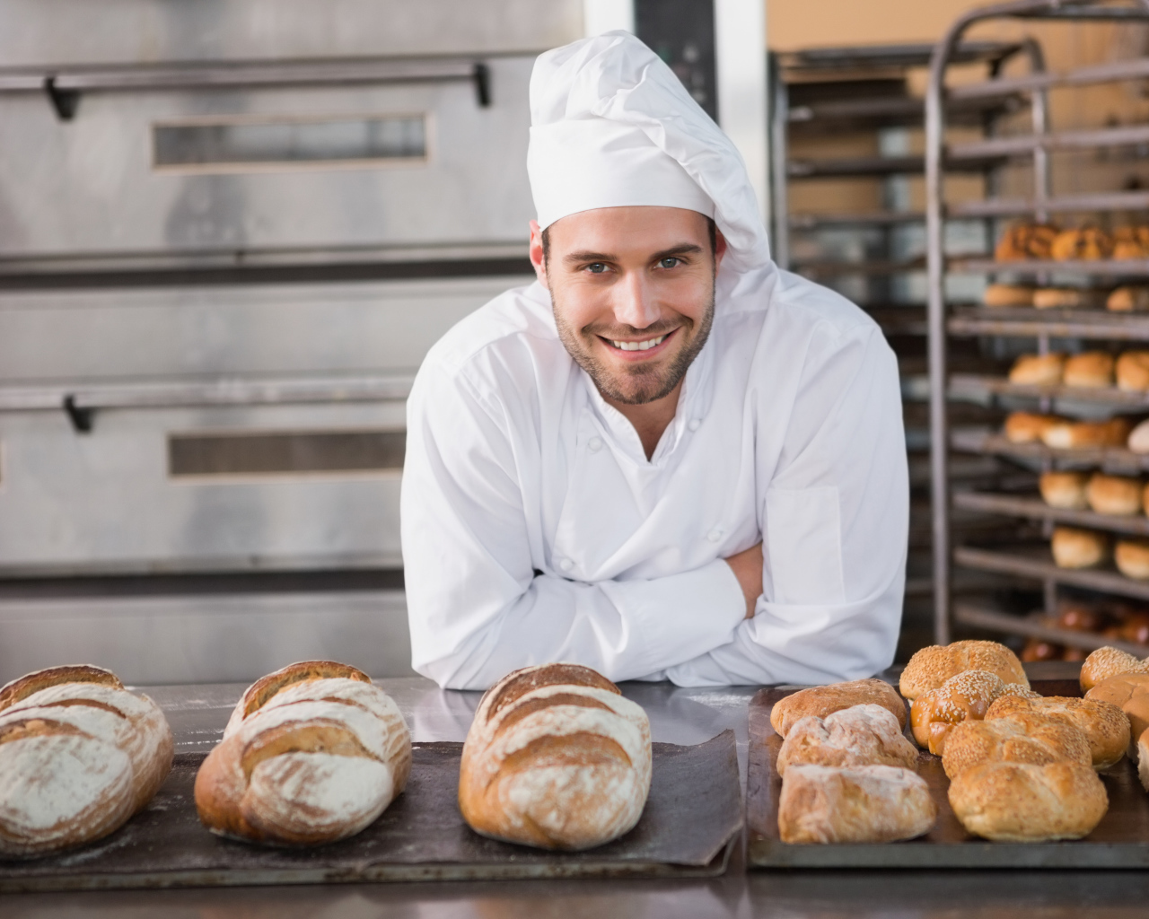Красивый улыбающийся мужчина пекарь в форме